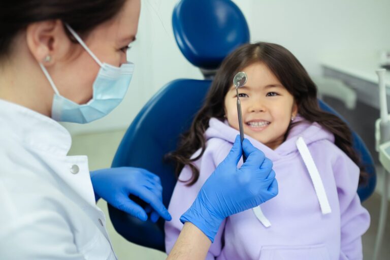 Dental professional showing tool to child during visit